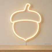 Watermarked concept mockup of Mini Acorn LED Neon Sign in Warm White on a clear acrylic backboard.