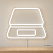 Watermarked concept mockup of Mini Coffee Scale LED Neon Sign in White on a clear acrylic backboard.