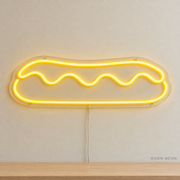 Watermarked concept mockup of Mini Eclair LED Neon Sign in Yellow on a clear acrylic backboard.