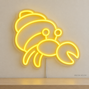 Watermarked concept mockup of Mini Hermit Crab LED Neon Sign in Yellow on a clear acrylic backboard.