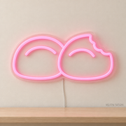 Watermarked concept mockup of Mini Mochi Pair LED Neon Sign in Pink on a clear acrylic backboard.