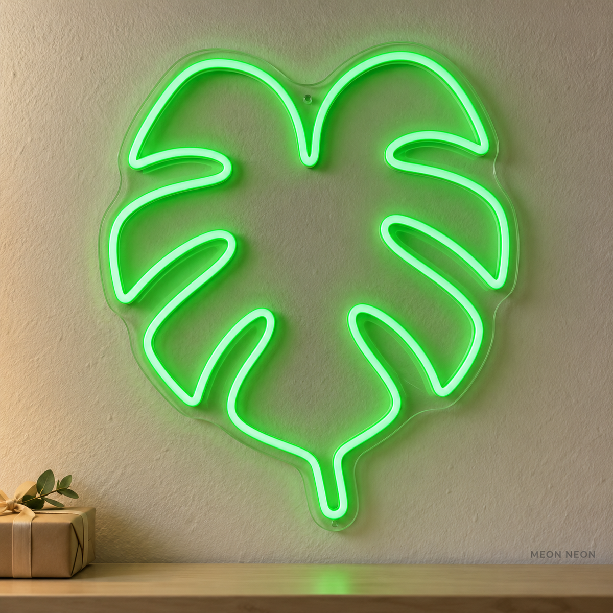 Watermarked concept mockup of the Mini Monstera Leaf LED Neon Sign in Green on a clear acrylic backboard.
