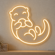Watermarked concept mockup of the Mini Otter LED Neon Sign in Warm White on a clear acrylic backboard.