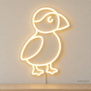 Watermarked concept mockup of Mini Puffin LED Neon Sign in Warm White on a clear acrylic backboard.