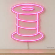 Watermarked concept mockup of Mini Thread Spool LED Neon Sign in Pink on a clear acrylic backboard.