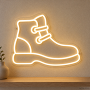 Watermarked concept mockup of Mini Trail Boot LED Neon Sign in Warm White on a clear acrylic backboard.