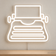 Watermarked concept mockup of Mini Typewriter LED Neon Sign in White on a clear acrylic backboard.
